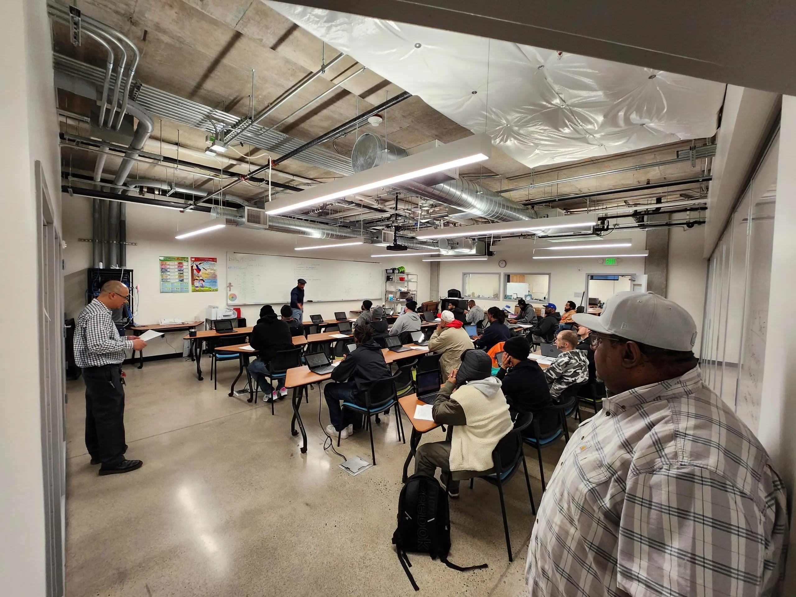 Adults sitting in a classroom with someone up at the front of a room