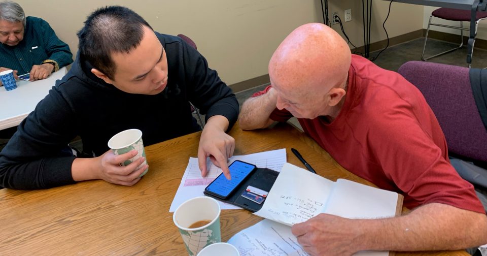 Someone helps another person with their phone