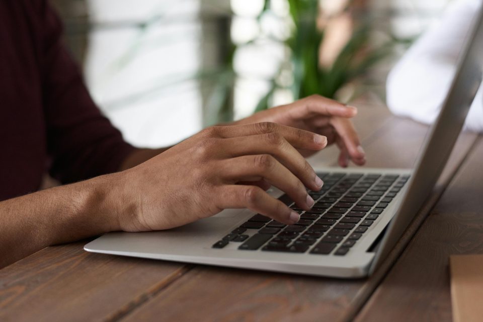 Close up of someone's hands typing on a laptop