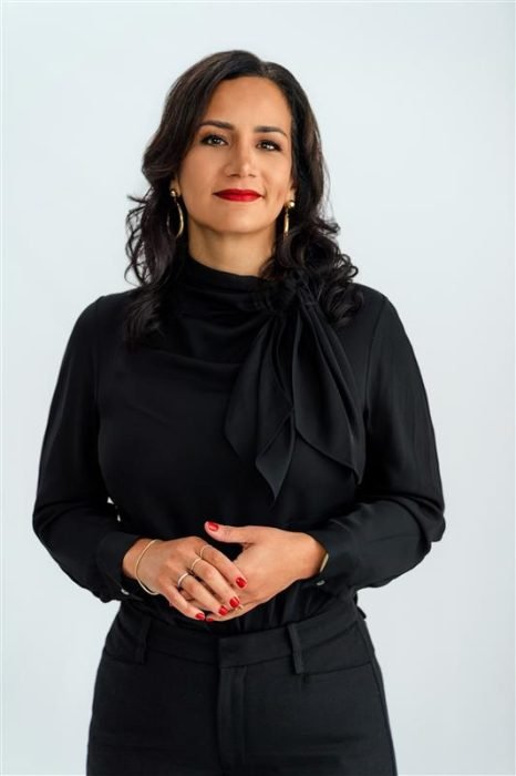 A woman in a black shirt and pants looking at the camera
