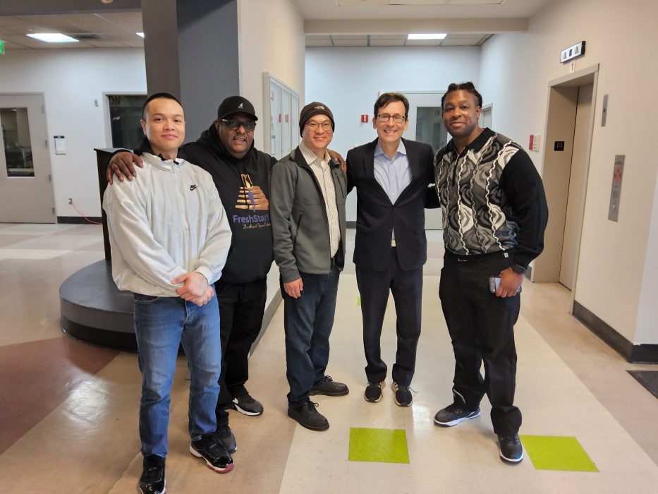 A group of men standing with then Attorney General Bob Ferguson