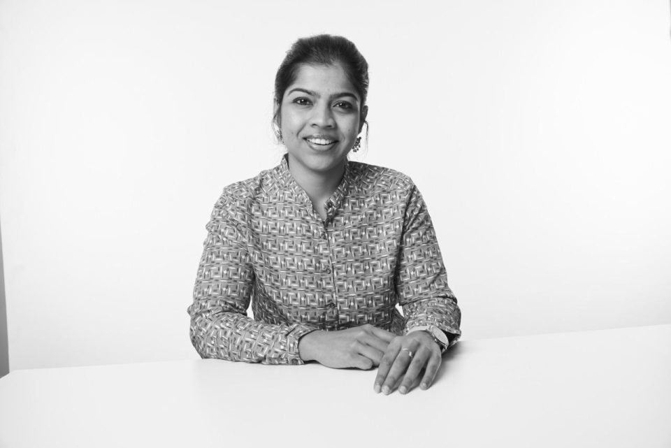 Subhechha Chatterjee, a 29-year-old Indian woman with her hair in a bun, smiling at the camera, in a black and white image