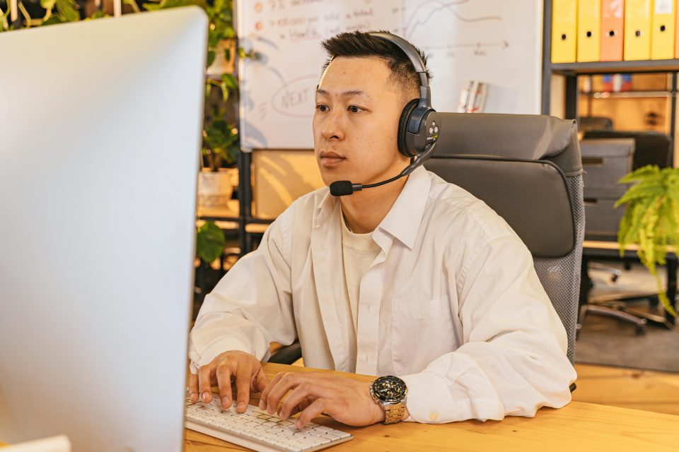 A man using a computer with a headset