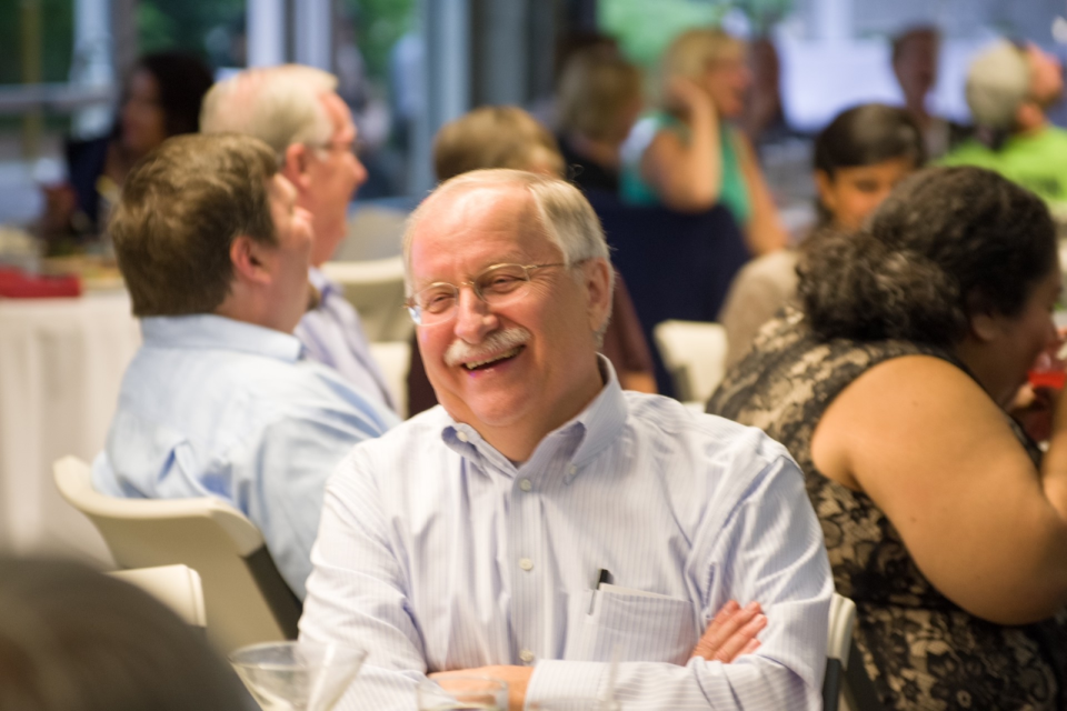 Frank Chopp sitting at a table smiling